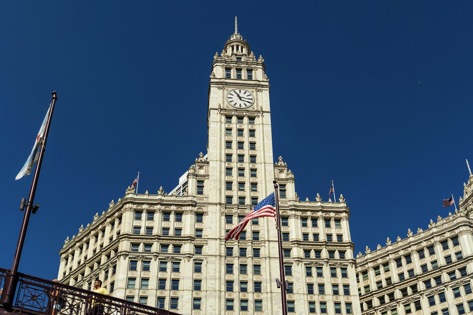 Daylight view of Chicago’s Wrigley Building with its clock tower and flags